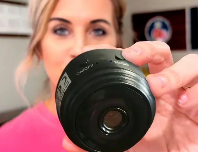Anna holding her PebblePeek camera in her kitchen